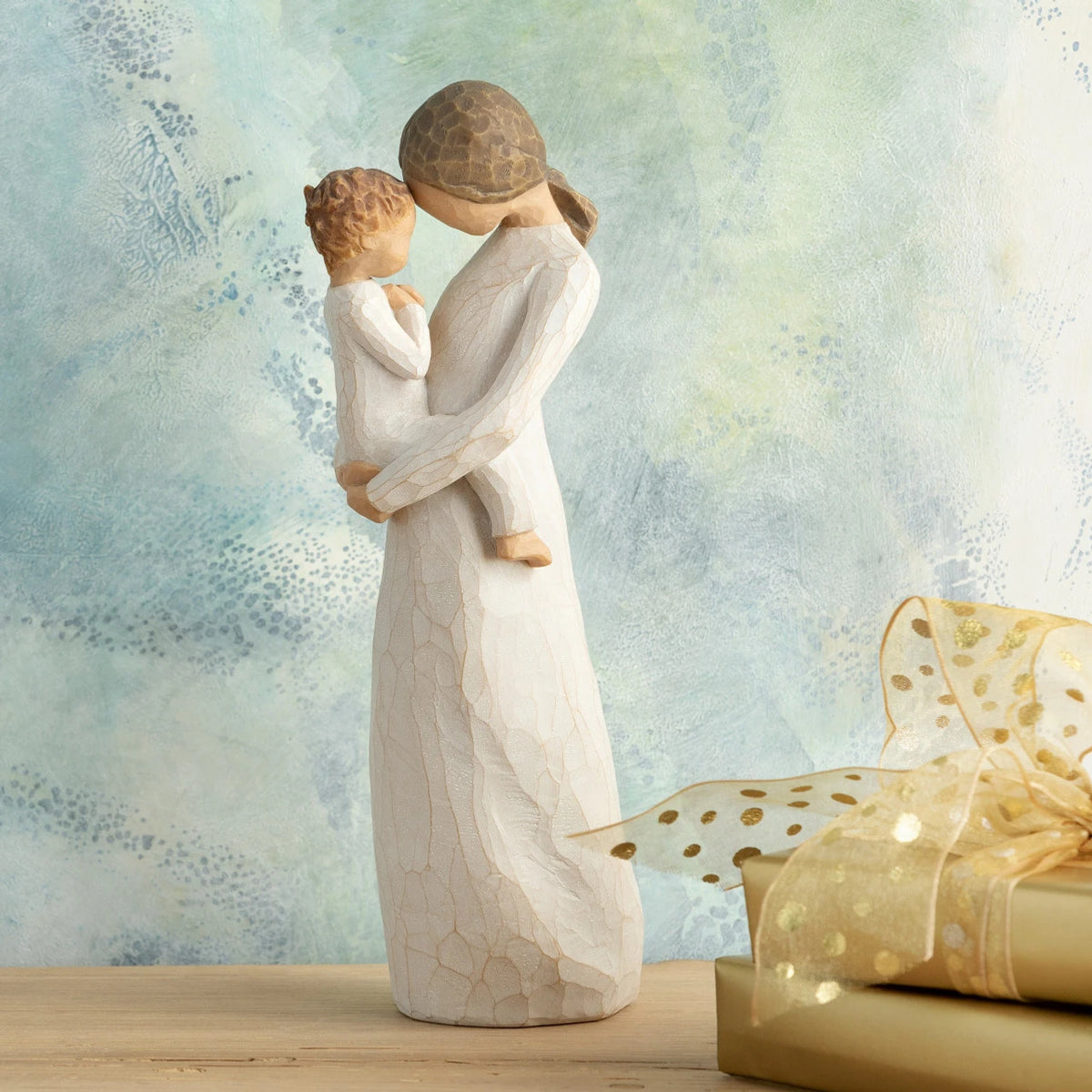 Willow Tree Tenderness, 8”h hand-painted standing resin figure holding toddler, foreheads touching, both dressed in cream, in front of blue painting