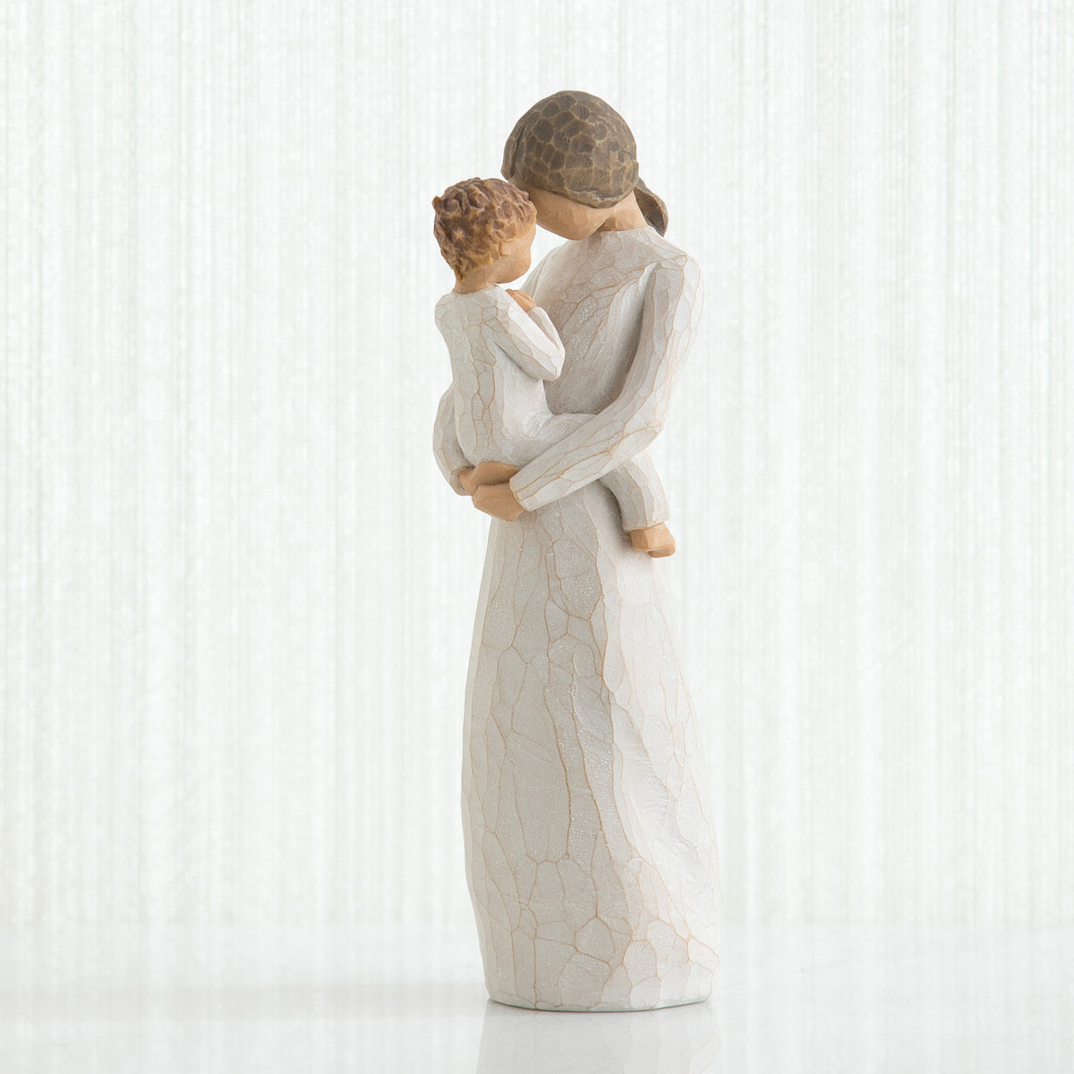 Mother figurine in white dress with brunette hair holding baby in white