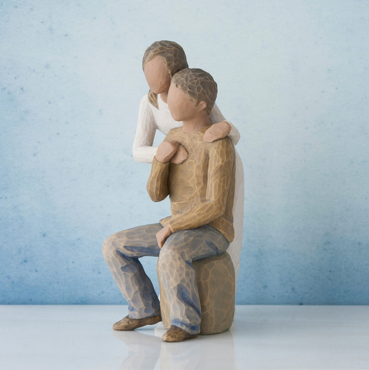 Man and woman figurine - man is in brown sitting down, woman is in white standing over him