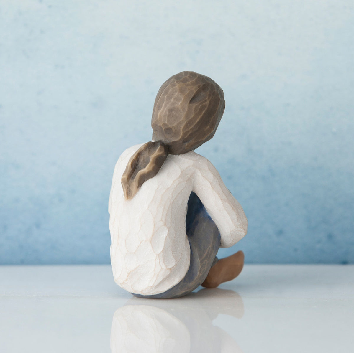 Back view of brunette girl sitting down in white shirt
