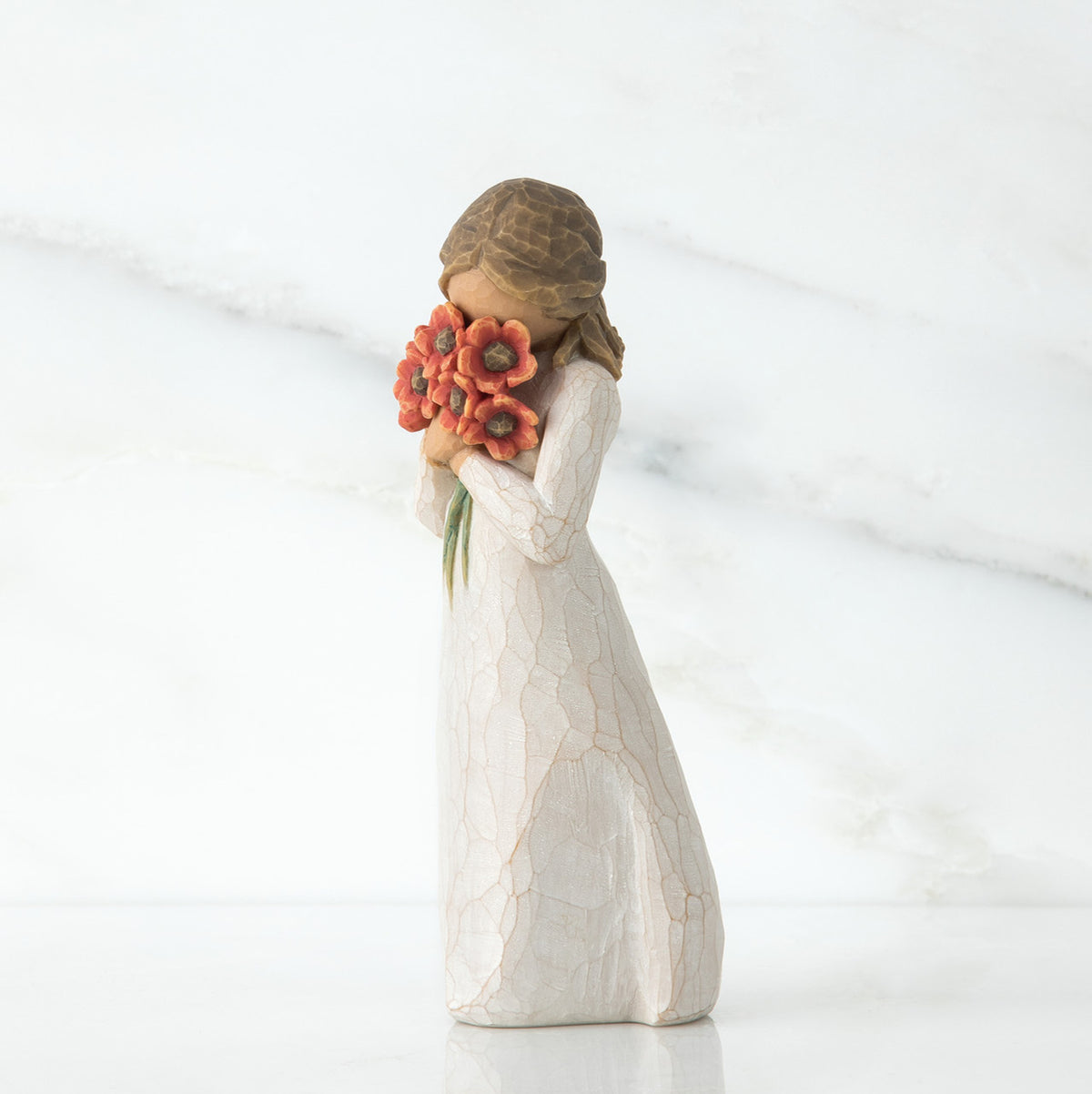 Brunette girl figurine in white dress holding orange flowers