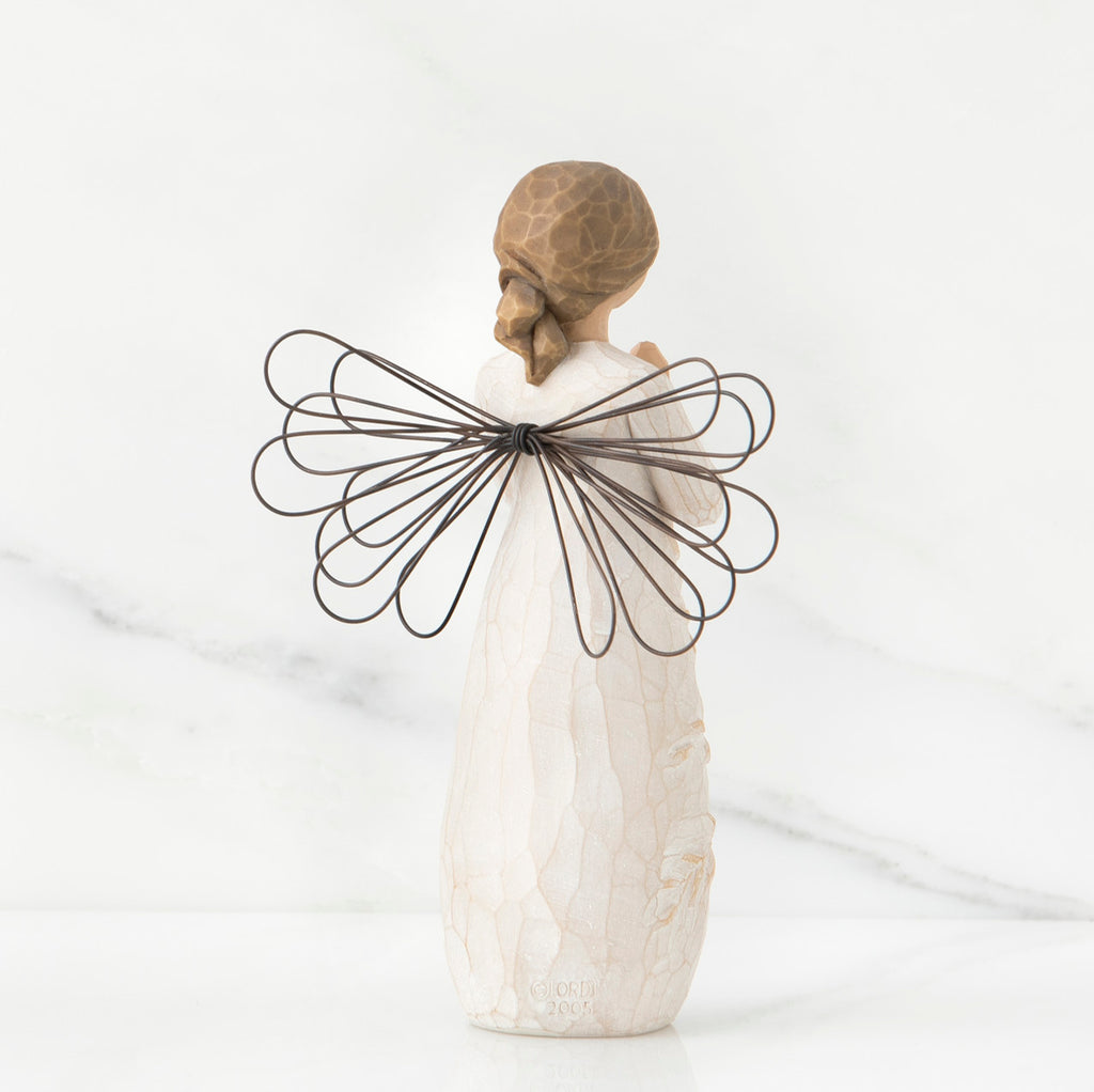 Back view of brunette girl figurine in white dress with brown wire wings standing up
