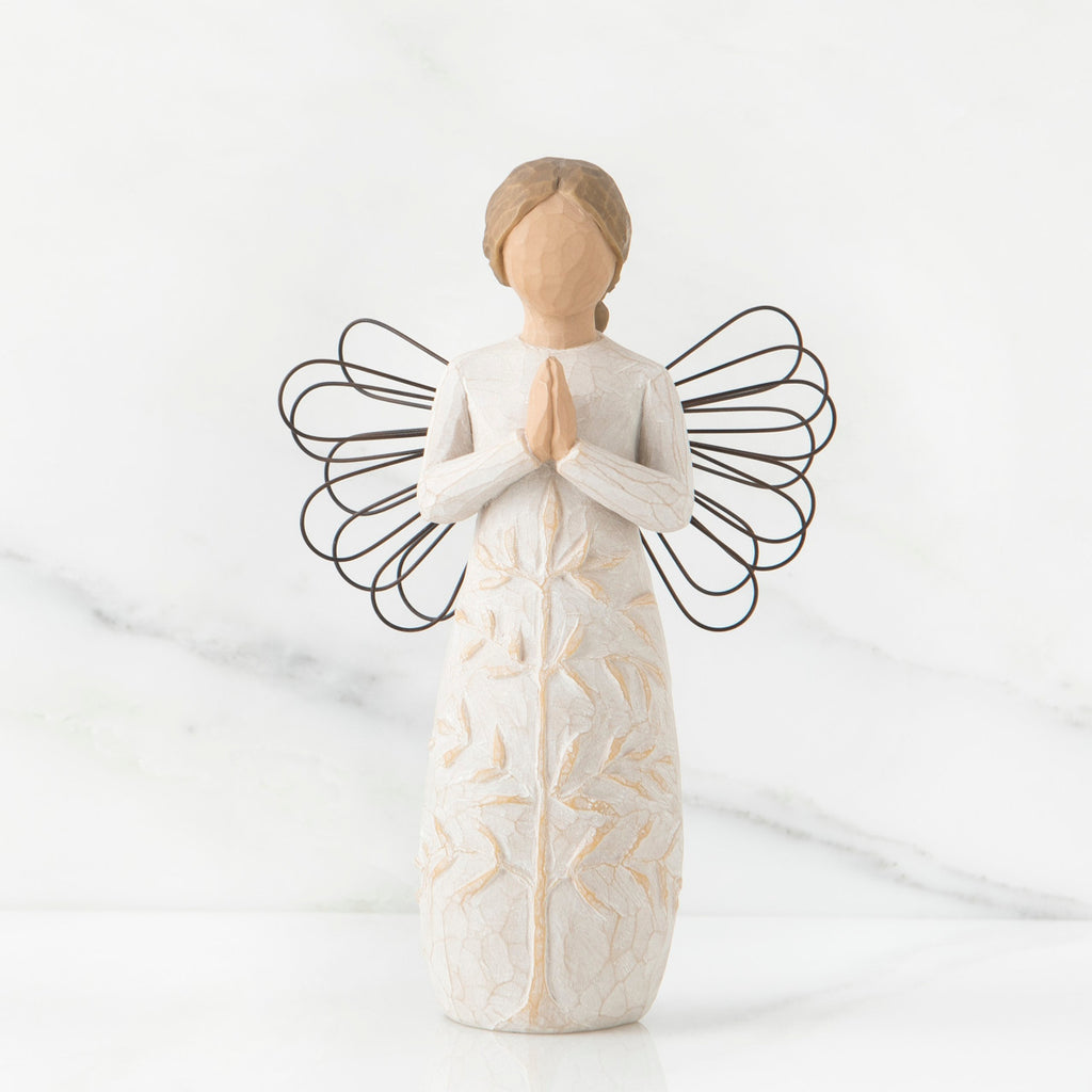 Faceless woman figurine in white dress with black wire angel wings - her hands are folded in prayer form